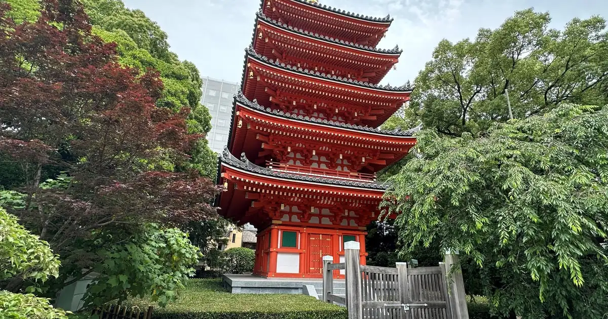 博多の旧市街、緑の木々の間に立つ東長寺の赤い五重塔