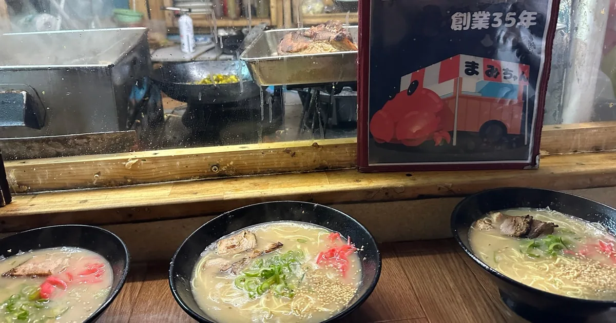 Drei Schalen cremiger Tonkotsu-Ramen auf der Theke eines Yatai-Imbissstands